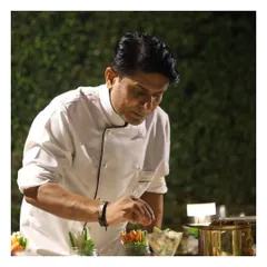 One of our senior chefs meticulously adding the final touches to a dish, reflecting the experience and artistry that anchors our culinary team.