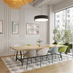 A collaborative table sits adjacent to the main reception, bathed in natural light from large windows. The classic wall molding and checkerboard rug add a touch of timeless elegance to the modern space.