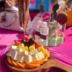 A cheese and fruit platter from a Squid Game themed party. The arrangement includes cheese cubes, grapes, strawberries, and breadsticks, offering a savory and fresh option for guests.