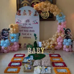 We design decorations that honor your family's traditions. This is a setup for a Chhathi ceremony, incorporating sacred elements like the Gayatri Mantra on the backdrop, marigold flower arrangements, and Bal Krishna motifs for a blessed celebration.