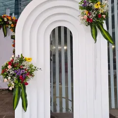 In addition to floral arches, I also create modern decor elements like this white tiered archway. Adorned with simple, elegant floral bouquets, it offers a contemporary alternative for event entrances or photo points.