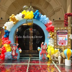 A close-up of the carnival entrance arch, detailed with monkey cutouts and a custom light-up sign for "Anamay's Carnival".