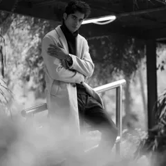 This atmospheric shot uses smoke or fog to create a dramatic, moody environment. The black and white conversion enhances the cinematic quality, making it a standout image in a fashion portfolio.
