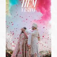 A vibrant and modern wedding moment, with the couple framed by a burst of colorful smoke and a shower of petals.