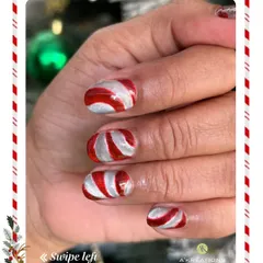 Sweet and festive candy cane nail art, featuring swirling red and silver stripes that capture the fun and magic of the holiday season.