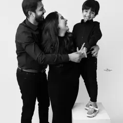 A candid and fun black and white shot of a family laughing together. These authentic moments of joy are what make a family photoshoot so special.