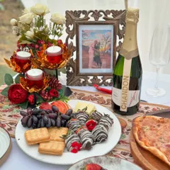 A close-up of the gourmet dining experience that awaits. We offer curated platters with items like chocolate-covered strawberries, cheese, crackers, and champagne to make your celebration extra special.
