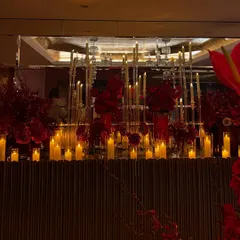 For a luxurious home birthday, we created a dramatic atmosphere using masses of crimson flowers and glowing candles on mirrored and metallic surfaces to reflect the light beautifully.