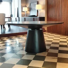 Here is another view of one of our favorite dining tables, showcasing its solid, conical base and expansive top. The dark finish gives it a commanding presence, perfect for modern and classic interiors alike.