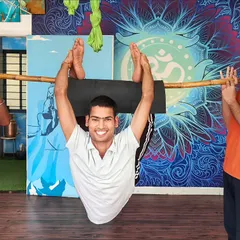 We creatively use props like this bamboo stick to help students safely explore advanced backbends. This method provides support while building the core strength and spinal flexibility needed for challenging asanas, making them accessible to more practitioners.
