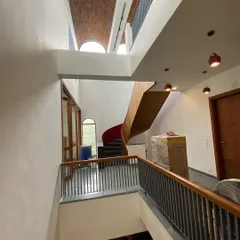 A wider perspective of the multi-height volumes, showing how the staircase connects the different levels beneath the dramatic brick ceiling.