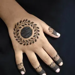 A close-up of the simple leaf-wreath mandala on a child's hand.
