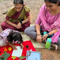 Three generations enjoying a moment of creativity together. A grandmother and mother watch as their little one gets absorbed in a nature art activity. My workshops are for the whole family.
