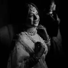 A beautiful black and white portrait capturing the bride's gentle smile, with a soft reflection in the background adding depth.
