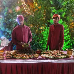 A live counter set against a backdrop of lush greenery and festive lights. My staff is ready to serve freshly prepared vegetarian starters to guests.