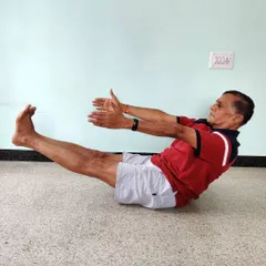 Paripurna Navasana (Full Boat Pose). This asana is a powerful tool for building core strength and mental endurance. The spine must remain straight, not rounded.