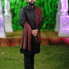 A full-length view of the black Jodhpuri and shawl combination. The client is wearing traditional footwear which completes this ethnic look for a wedding guest.