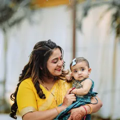 A mother's gentle hold and a baby's curious gaze. This is the kind of natural, emotional moment we love to capture during family events like first birthday parties.