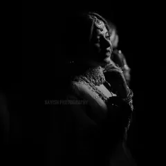 A moody and artistic black and white photo, where shadows and light play to create a mysterious and elegant bridal silhouette.
