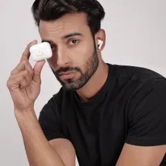 A model holding a white earbud case, with one earbud in his ear. This shot clearly displays the product and its charging case in a relatable human context.
