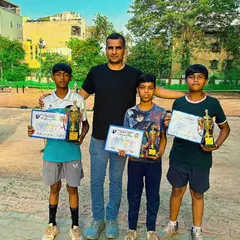 Champions Ansh, Satish, and Naman with their coach and their trophies. I am proud of their performance and their winning attitude on the court.