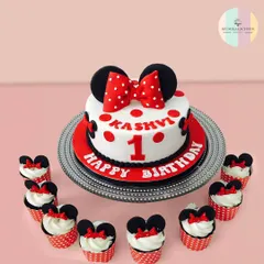 A magical first birthday for Kashvi with this adorable Minnie Mouse cake and matching cupcakes. The classic red, white, and black theme with polka dots and bows is a timeless choice for a little one's special day.