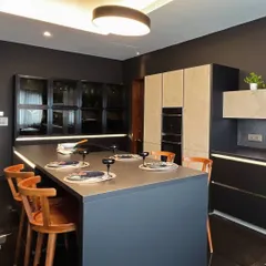 The island in the Mibu Residence serves as a central hub, combining a dining space with the cooking area. The contrast between the AV2035 Black Lacquer and the stone-like AV8000 Beton Ceramic creates a grounded yet dramatic feel.