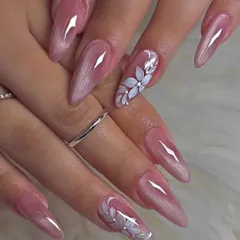 For a soft and romantic bridal style, we created these long, pearlescent pink nails. The look is elevated with a single accent nail on each hand, featuring a beautifully hand-painted white floral design.