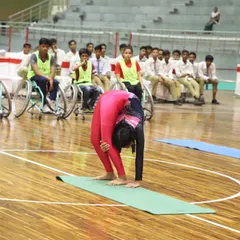 A young gymnast performs an incredible feat of flexibility during our National Sports Day celebration. The event also honored wheelchair basketball medalists, showcasing our commitment to inclusive sports.
