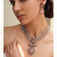 A beautiful necklace and earring set featuring soft pink stones and polki, strung on a multi-strand grey beaded chain for a subtle, elegant look.