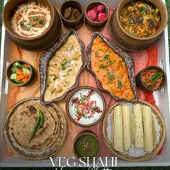 A feast fit for royalty. Our Veg Shahi Khwan Platter is a luxurious spread of rich North Indian dishes, including two types of paneer, dal makhani, biryani, assorted breads, and pickles, all served in beautiful earthenware.