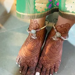 A full-coverage bridal feet mehendi with intricate patterns that complement the bride's anklets beautifully.