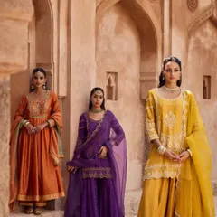 A vibrant trio of festive wear, showcasing rich jewel tones in orange, purple, and yellow. These outfits, with their unique silhouettes and detailed embroidery, are perfect for any celebration.