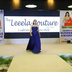 A model takes center stage in a custom navy blue strapless ball gown during the Celebrity Business Awards show. The minimalist design highlights the rich fabric and expert tailoring.