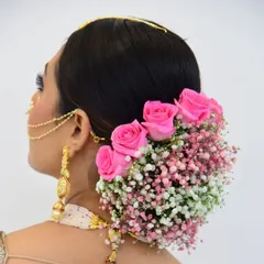 A classic floral bun is always a beautiful choice for traditional events. I created this intricate low bun and adorned it with a combination of fresh pink roses and baby's breath, ensuring it looks stunning from every angle.