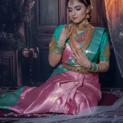 A full South Indian bridal look with a stunning pink and teal Kanjeevaram saree, demonstrating how to balance bold colors.