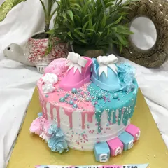 This view highlights the colorful sprinkles and drips on the gender reveal cake.