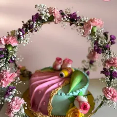 I designed this cake to look like an elegant saree, complete with a delicate floral arch. It was for a very special occasion, blending traditional art with modern baking. I used fresh cream and fondant to create the draping effect and intricate details.
