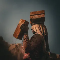 A worker is captured in motion, dust flying as they handle bricks, with the dramatic lighting highlighting their strength and the physicality of the labor.