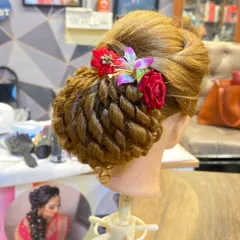 This close-up highlights the clean, twisted sections and the placement of the floral accessories in this advanced bridal hairstyle.
