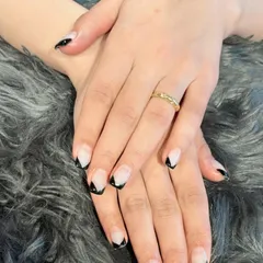 This V-shaped French tip in classic black offers a chic and edgy alternative to the traditional curved line. It's a great way to elongate the look of your nails.