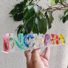 A colorful resin name stand I created for a client. Each letter is filled with different colored flowers and pigments, creating a vibrant and playful piece of personalized desk decor.