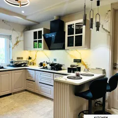 Another view of the completed Amar Colony kitchen, highlighting the elegant cabinetry and statement lighting. The design is a perfect balance of classic charm and modern functionality.
