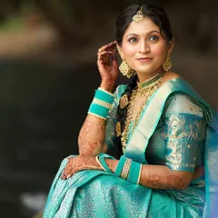 A serene portrait of the bride in her turquoise Kanjeevaram silk saree. The makeup is elegant and timeless, perfectly complementing the rich attire.