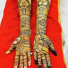 This is a beautiful example of a bridal design that combines floral patterns with geometric checks and peacock motifs. The fingertips are kept dark for a traditional look.
