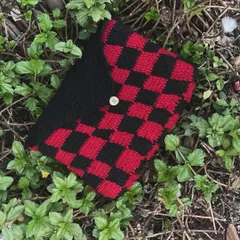 This handmade book protector looks great against the green foliage. It's perfect for anyone who loves reading and wants to keep their books nice.