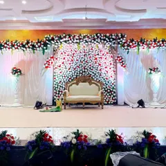 For this indoor wedding reception, I created a wide stage with a backdrop of dense red and white flowers. The design is framed by a floral arch and complemented by elegant white draping and multiple spotlights to highlight the intricate details.