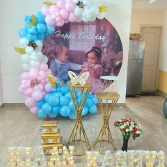 I also create beautiful setups for twins' birthdays. This decoration for Naan and Kashvi's birthday features a custom photo backdrop of the twins, surrounded by a pink and blue balloon arch and their names in marquee letters.