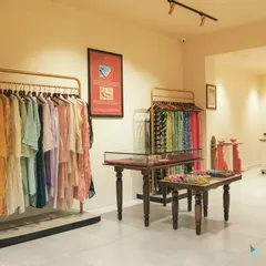 To display the clothing, we used minimalist brass-finished clothing racks and hand-carved wooden tables. This allows the intricate designs and rich colors of the garments to be the center of attention.