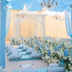 A breathtaking setup inspired by the cool blues of Jaipur. The low seating with block-printed cushions, surrounded by a sea of blue and white flowers, created a serene and royal ambiance for an afternoon event.